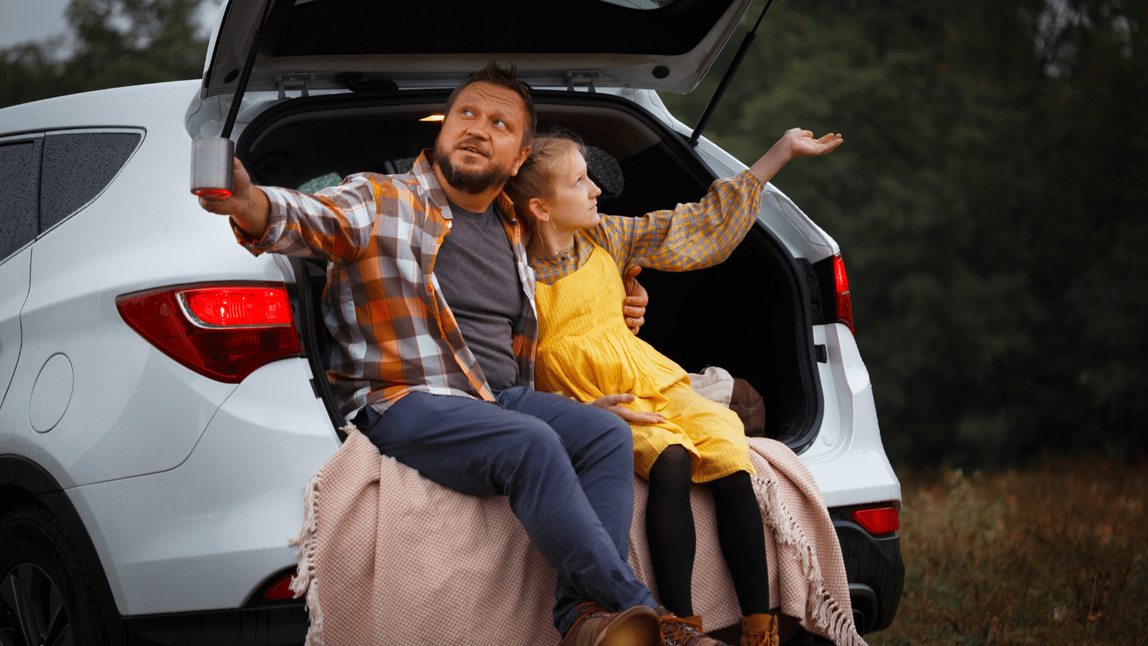 a father and a daughter sitting in a car trying to avoid the rain