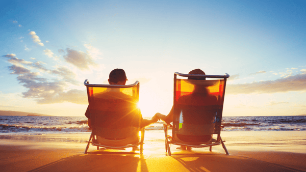 couple sitting on a beach on an all-inclusive vacation