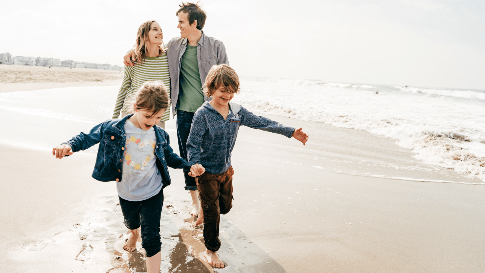 family of four happily enjoying on a beach