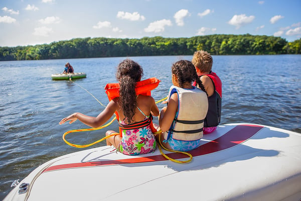 kids sitting on a boat having fun at the lake