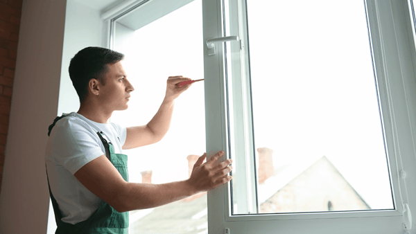 man repairing window coverings